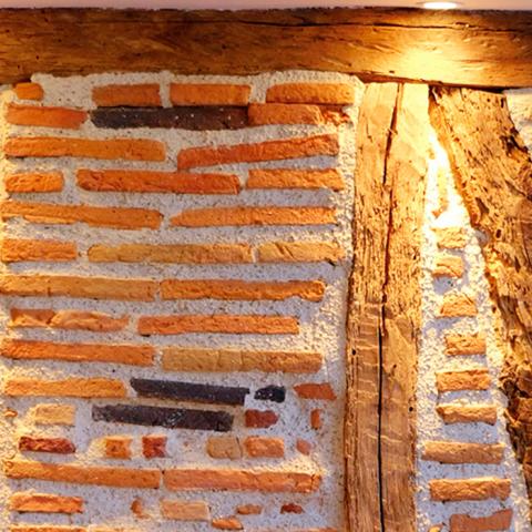 Un muro de entramado en una habitación del Préau Saint-Jacques, casa de huéspedes en Castres